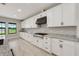 Bright, eat-in kitchen with white cabinets, granite countertops, and stainless steel appliances at 14403 Woodland Spur Dr, Lithia, FL 33547