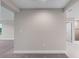 Open living room with neutral color palette, plush carpet, and access to the main bedroom at 14403 Woodland Spur Dr, Lithia, FL 33547