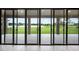 Covered patio with expansive sliding doors offering picturesque views of the backyard and lake at 14403 Woodland Spur Dr, Lithia, FL 33547