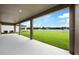 Covered patio with views of a well-manicured lawn and serene pond at 14403 Woodland Spur Dr, Lithia, FL 33547