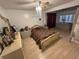 Traditional bedroom features a ceiling fan, hardwood floors, and a dresser with decorative objects at 14633 Sassandra Dr, Odessa, FL 33556