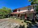Charming two-story home featuring a screened porch, red accents, and mature landscaping at 14633 Sassandra Dr, Odessa, FL 33556