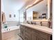 Bright bathroom featuring a double sink vanity, soaking tub and tile flooring at 15407 Quail Woods Pl, Ruskin, FL 33573