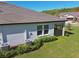 Spacious backyard featuring lush green grass, landscaping, a screened in porch, and modern air conditioning units at 16710 Shell Bay Dr, Land O Lakes, FL 34638