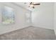 A bedroom with neutral carpet, bright windows, and a ceiling fan at 16710 Shell Bay Dr, Land O Lakes, FL 34638