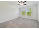 Bright bedroom with neutral carpet, ceiling fan, and two windows with blinds at 16710 Shell Bay Dr, Land O Lakes, FL 34638