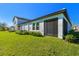 Exterior side view of home with a screened in patio, green grass, and bushes at 16710 Shell Bay Dr, Land O Lakes, FL 34638