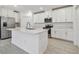Modern kitchen featuring white cabinets, stainless steel appliances, and a large island at 16710 Shell Bay Dr, Land O Lakes, FL 34638