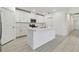 A modern kitchen with an island, white cabinets, and stainless steel appliances for an open design at 16710 Shell Bay Dr, Land O Lakes, FL 34638
