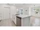 A bright modern kitchen with a stainless steel sink, light countertops, and tile flooring at 16710 Shell Bay Dr, Land O Lakes, FL 34638