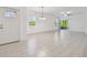 Open living space with neutral tile flooring, abundant natural light, and access to outdoor screened patio at 16710 Shell Bay Dr, Land O Lakes, FL 34638