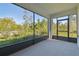 View from inside a screened porch with a view of trees and a glimpse of a walking path at 16710 Shell Bay Dr, Land O Lakes, FL 34638