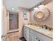 Bathroom featuring a granite countertop vanity, decorative mirror, and beautifully tiled shower with a glass door at 1901 Oyster Catcher Ln # 823, Clearwater, FL 33762