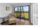 Bright sitting area with a view of the golf course, natural light, and a cozy armchair at 1901 Oyster Catcher Ln # 823, Clearwater, FL 33762