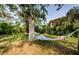 Relaxing backyard with a hammock strung between mature trees and lush greenery at 2261 Queen S St, St Petersburg, FL 33712