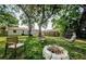 Expansive backyard featuring mature trees, seating, hammock, fire pit and a hanging swing chair at 2261 Queen S St, St Petersburg, FL 33712