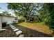 Spacious backyard with mature trees, lush landscaping, and a serene setting ideal for outdoor activities and relaxation at 2261 Queen S St, St Petersburg, FL 33712