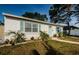 Charming single-story home with a well-manicured lawn, garden beds and blue window shutters at 2261 Queen S St, St Petersburg, FL 33712