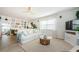 Cozy living room featuring a comfortable white sofa, stylish decor, and ample natural light from a large window at 2261 Queen S St, St Petersburg, FL 33712