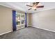 Spacious bedroom featuring carpet flooring, a ceiling fan, and a window with curtains at 2312 Heron Cir, Clearwater, FL 33762