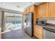 Well-lit kitchen featuring stainless steel refrigerator and sliding glass doors to the pool at 2312 Heron Cir, Clearwater, FL 33762