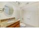 Bright bathroom boasts a round mirror, granite vanity and a shower-tub combination at 2581 Forest Run Ct, Clearwater, FL 33761