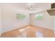 Charming bedroom featuring wood flooring, two windows, and a ceiling fan at 2581 Forest Run Ct, Clearwater, FL 33761