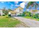 Charming two-story house with lush greenery, a well-maintained lawn, and a convenient carport area at 2581 Forest Run Ct, Clearwater, FL 33761