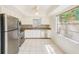 Well-lit kitchen with stainless steel appliances, light wood cabinets, granite countertops, and tile floors at 2581 Forest Run Ct, Clearwater, FL 33761