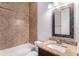 Bathroom featuring granite counters, tile shower, and decorative mirror at 260 Moccasin Hollow Rd, Lithia, FL 33547