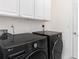 Laundry room features front load washer and dryer, plus white cabinets above and tile flooring at 260 Moccasin Hollow Rd, Lithia, FL 33547