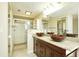 The bathroom is appointed with vessel sinks, granite counters, wood cabinets, large mirrors and modern fixtures, and glass enclosed shower at 3103 Taragrove Dr, Tampa, FL 33618