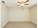 This empty bedroom features tan carpet, neutral walls, and a ceiling fan with light at 3103 Taragrove Dr, Tampa, FL 33618