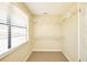 Spacious walk-in closet with built-in shelving offers storage, carpeted flooring, and a window for natural light at 3103 Taragrove Dr, Tampa, FL 33618