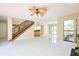 Spacious living room with tile floors, ceiling fan, wet bar, staircase, and sliding glass doors at 3103 Taragrove Dr, Tampa, FL 33618