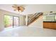 Open living room with a wet bar, staircase, tile floors, and access to the outdoor patio at 3103 Taragrove Dr, Tampa, FL 33618