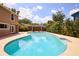 Backyard pool with surrounding patio, lush landscaping, wood fence, and exterior of a tan two-story house at 3103 Taragrove Dr, Tampa, FL 33618