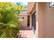 Side entrance of the tan house showing a red brick walkway and lush vegetation at 3103 Taragrove Dr, Tampa, FL 33618