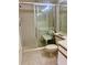En-suite bathroom featuring a shower with glass door, a seat, and a white toilet at 3629 Indigo Pond Dr # 3629, Palm Harbor, FL 34685