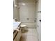 Bathroom showcasing a tub with tile surround, a white toilet, and single sink vanity at 3629 Indigo Pond Dr # 3629, Palm Harbor, FL 34685