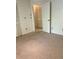 Bedroom with neutral colored carpet, a closet with folding doors, and an open door at 3629 Indigo Pond Dr # 3629, Palm Harbor, FL 34685