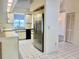 Bright eat-in kitchen featuring white cabinetry, tile floors, and stainless steel refrigerator at 3629 Indigo Pond Dr # 3629, Palm Harbor, FL 34685