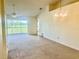 Spacious carpeted living room with access to a lanai and classic lighting fixture at 3629 Indigo Pond Dr # 3629, Palm Harbor, FL 34685