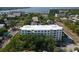 Aerial view of condo building surrounded by lush trees, with a glimpse of the water in the distance at 406 W Cedar St # 403, Tampa, FL 33606
