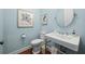 Charming powder room featuring pedestal sink, stylish fixtures, and elegant artwork for a sophisticated touch at 4105 W Corona St, Tampa, FL 33629