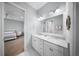 Bright bathroom featuring double sinks, white cabinets, and white and gray patterned flooring at 4105 W Corona St, Tampa, FL 33629