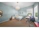 Light-filled bedroom featuring a charming chandelier, desk, and ample natural light from two windows at 4105 W Corona St, Tampa, FL 33629
