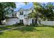 Charming two-story home with a manicured lawn, a balcony and a pink front door at 4105 W Corona St, Tampa, FL 33629