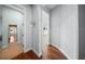 Hallway with hardwood flooring leading to rooms featuring white doors and trim at 4105 W Corona St, Tampa, FL 33629