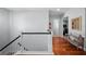 Elegant hallway with hardwood floors, white railing staircase, and a glimpse into adjacent rooms at 4105 W Corona St, Tampa, FL 33629